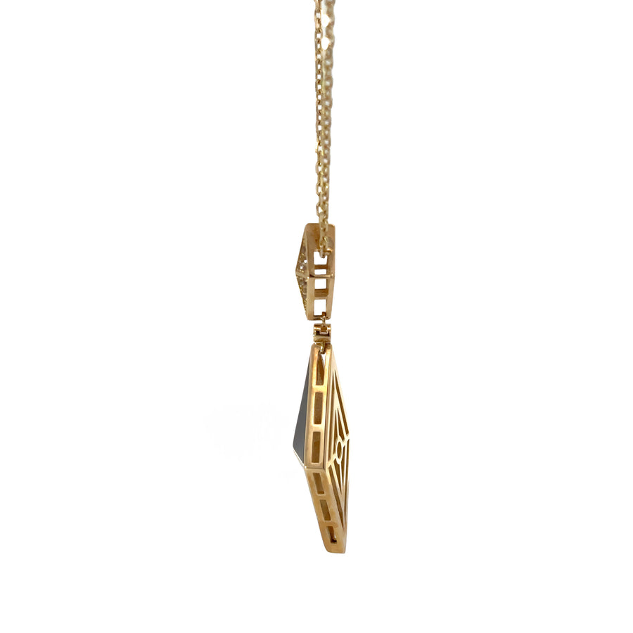 Close-up of geometric rhombus pendant on 14k gold chain