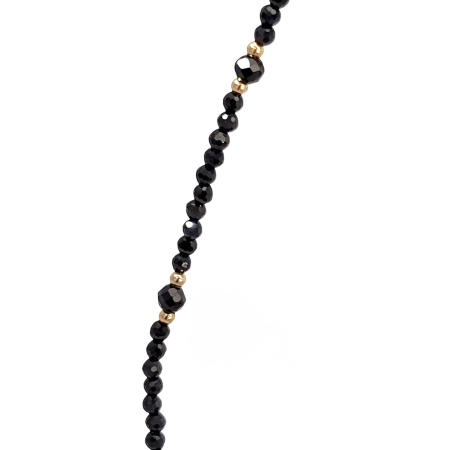 Necklace laid flat showing synthetic stones set in 14k gold