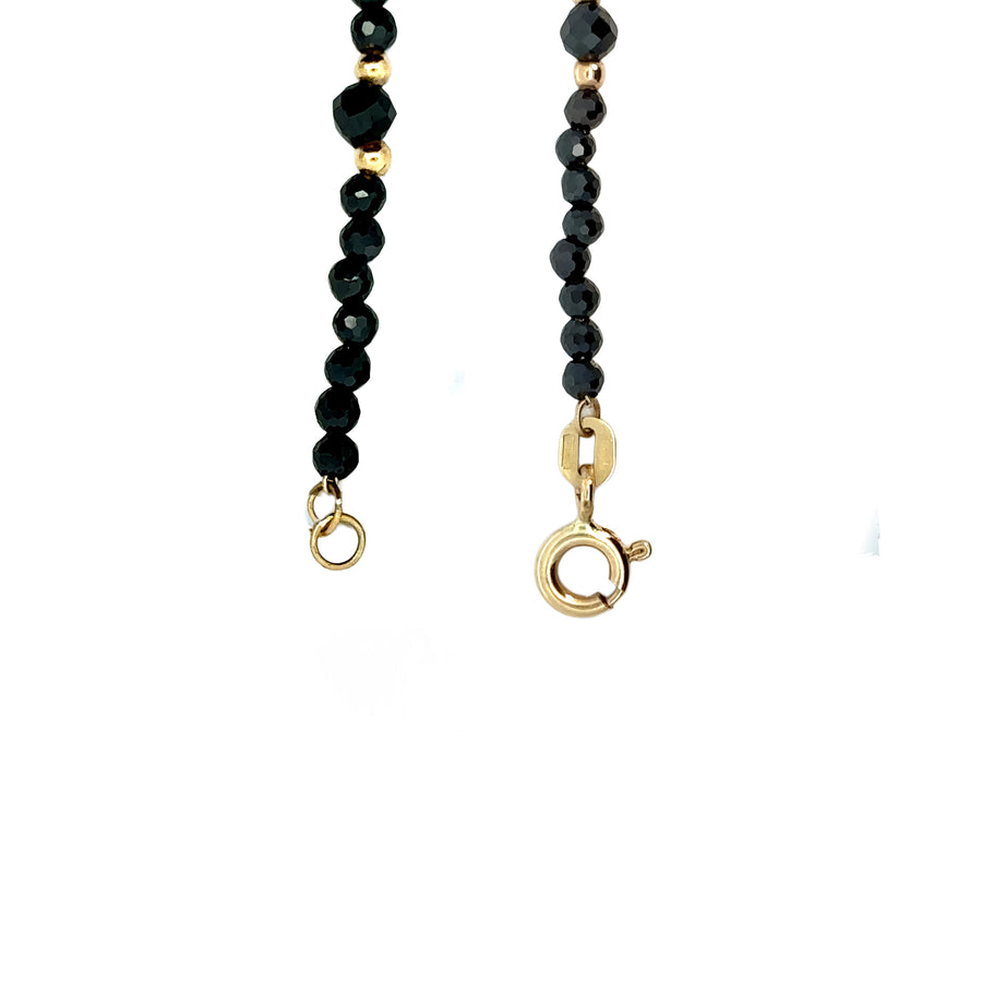 Side view of 14k gold necklace featuring synthetic stones