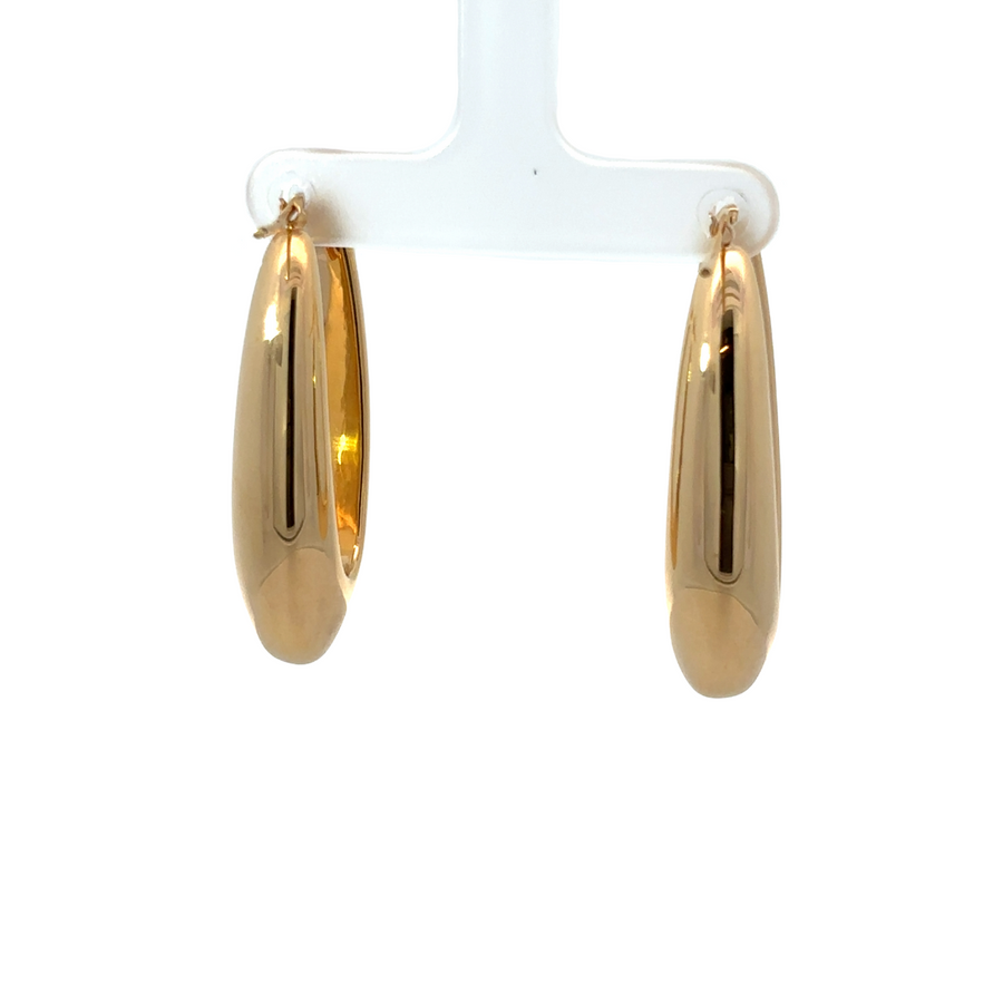 Woman wearing 14k gold oval earrings with everyday outfit