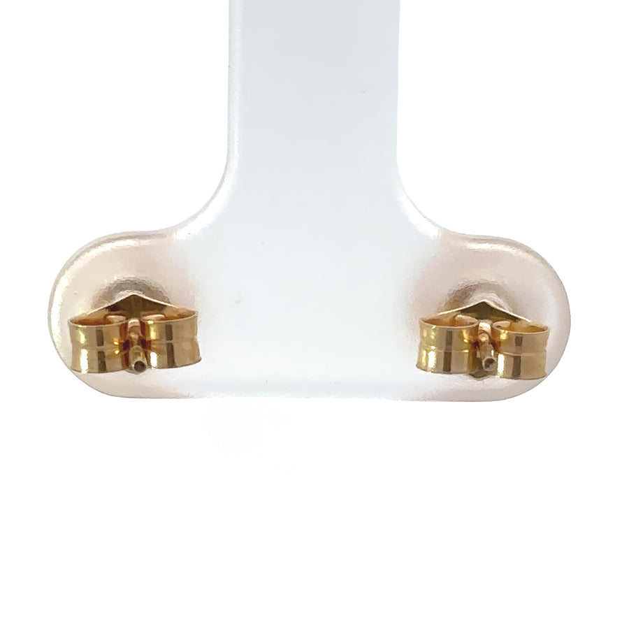 Baby wearing delicate 14k gold pearl stud earrings