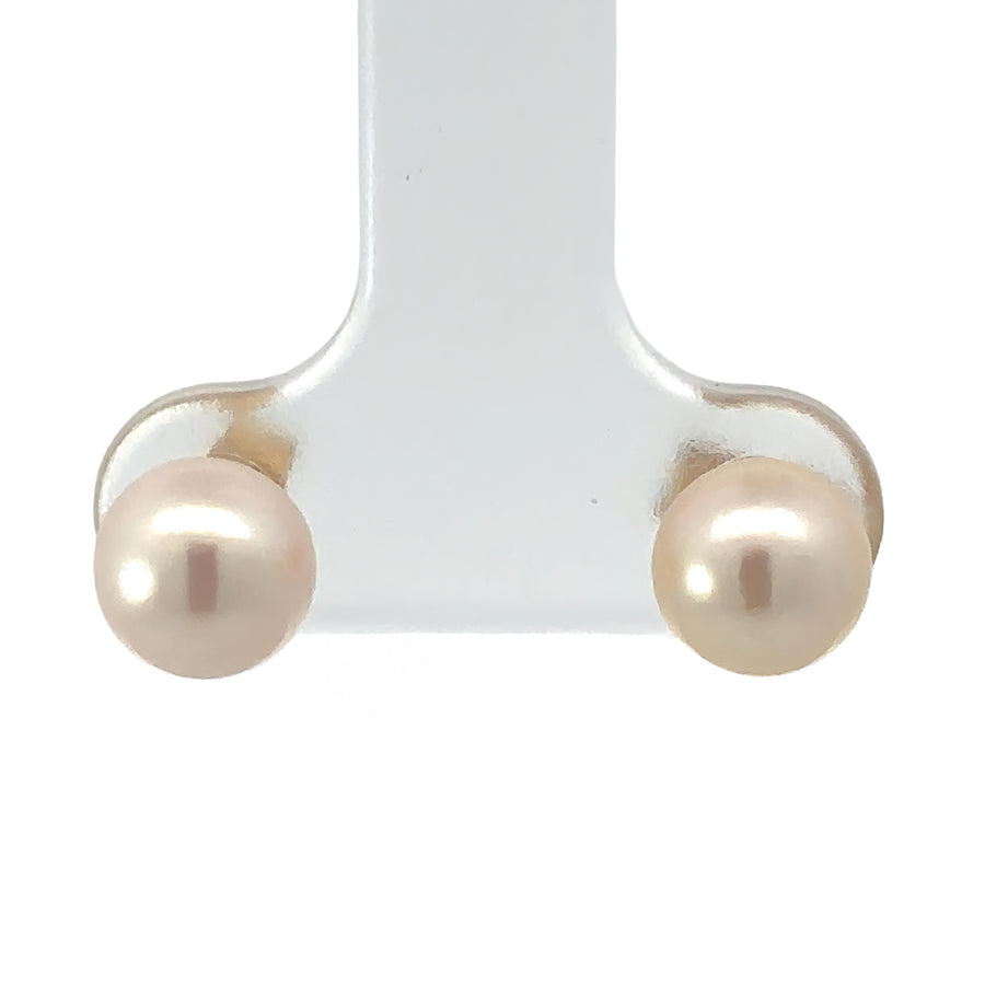 Close-up of 14k gold pearl earrings on white background