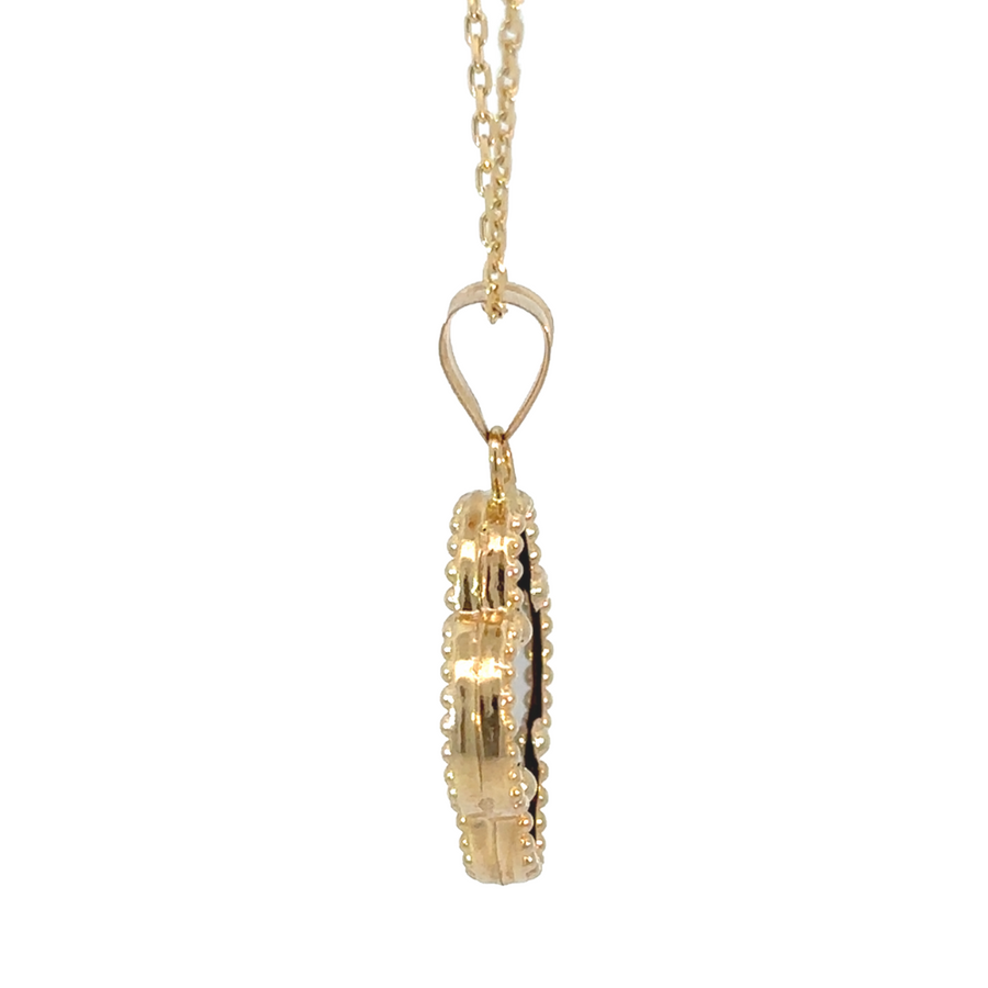 Minimalist gold pendant resting on linen fabric