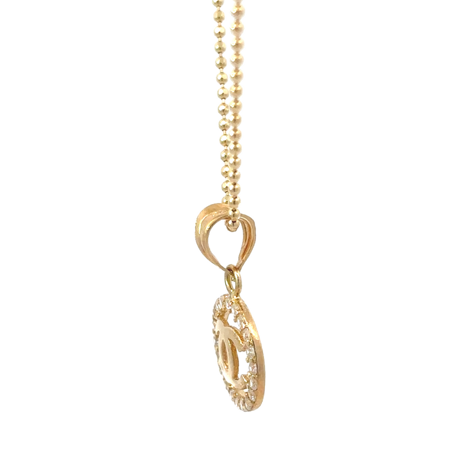 Side angle of 14k gold pendant highlighting polished gold finish