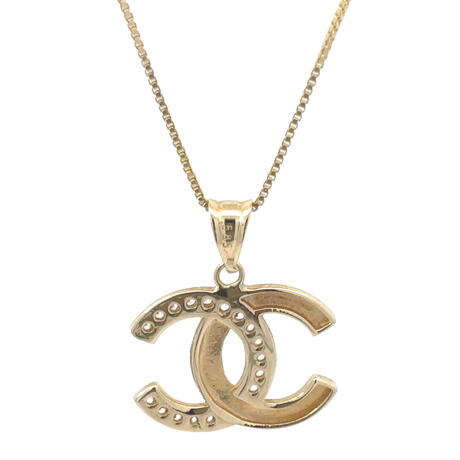 Unisex model wearing 14k gold pendant with CZ in a minimalist outfit