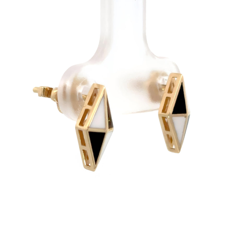 Woman wearing bold 14k gold rhombus stud earrings with black and white details