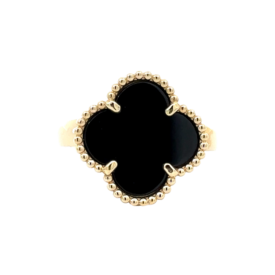Close-up of 14k gold ring with bold black accent against a white background