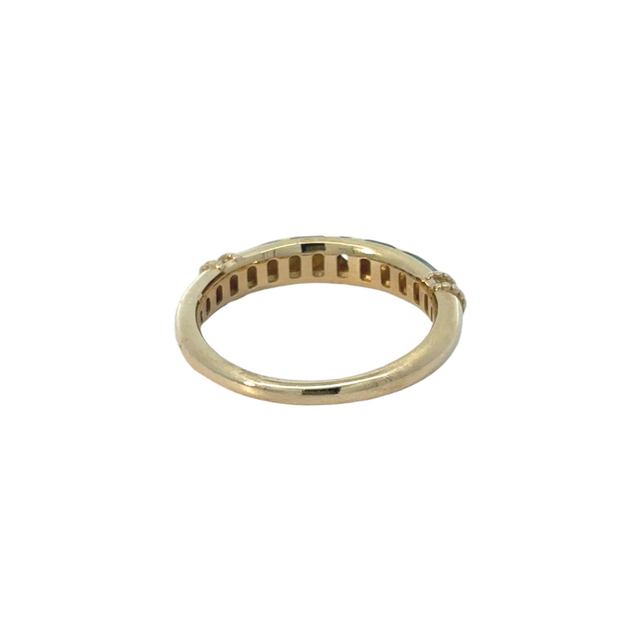 Woman wearing 14k gold ring with green enamel and CZ accents