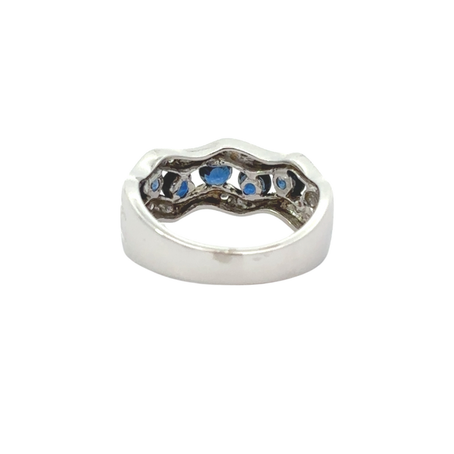 14k gold ring with sapphire and diamond details displayed on a reflective surface