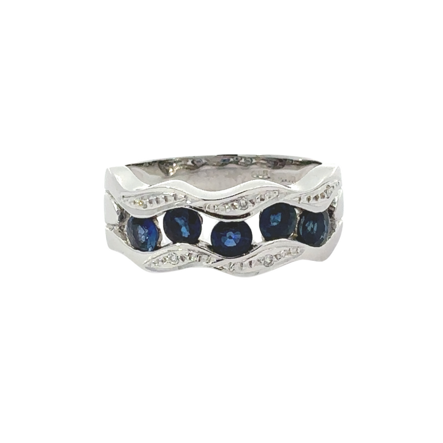14k gold sapphire ring with sparkling diamond accents resting on a soft fabric background