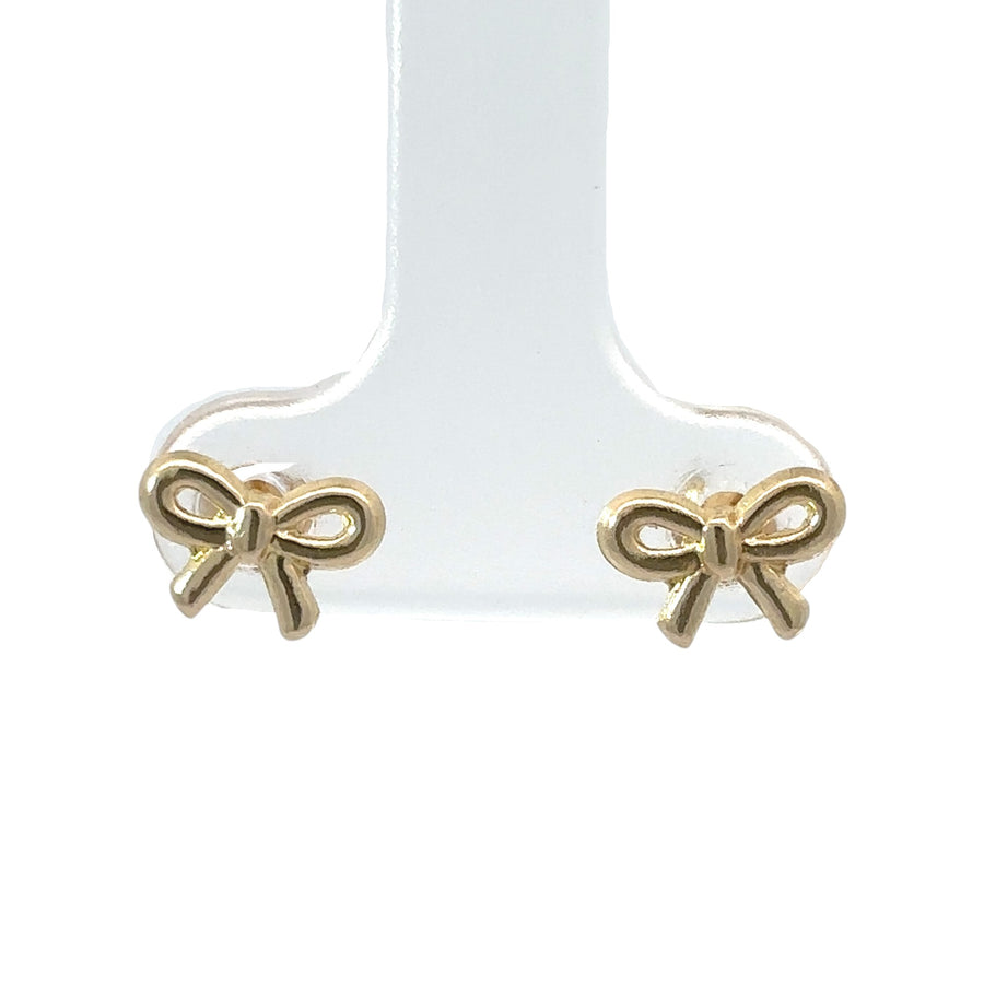 Close-up of solid bow design in 14k gold baby earrings