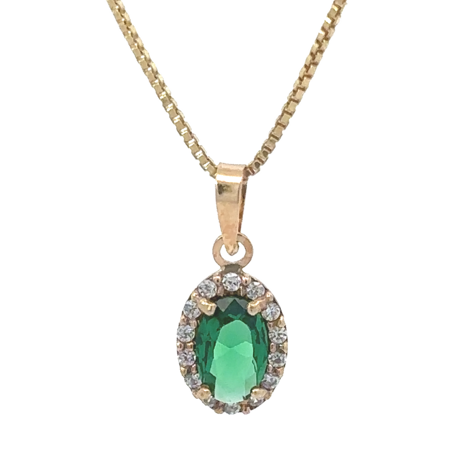 Minimalist oval pendant in 14k gold resting on a jewelry box