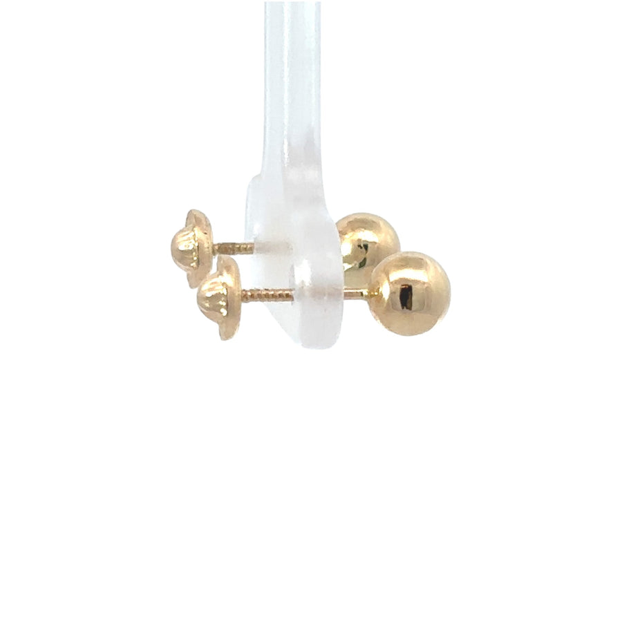Woman wearing classic 14k gold small ball stud earrings