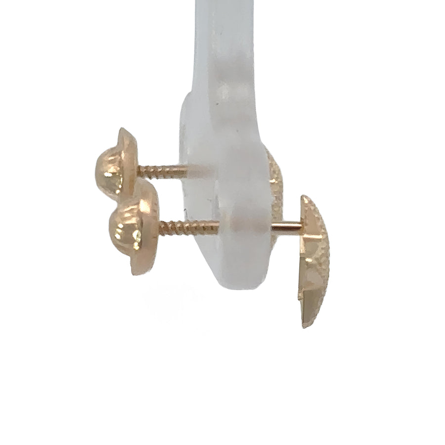 Baby wearing 14k gold small star center stud earrings