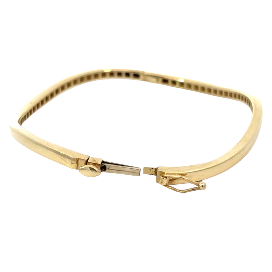 Delicate solid gold bangle styled for formal occasion