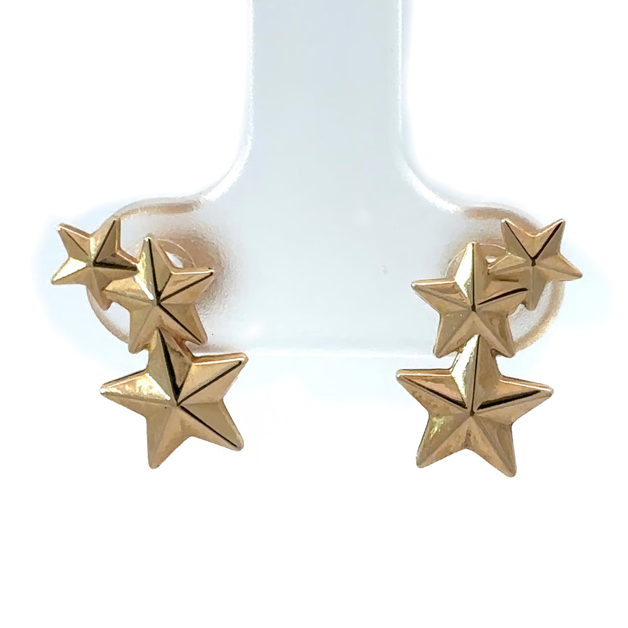 Close-up of delicate 14k gold star earrings with secure backings