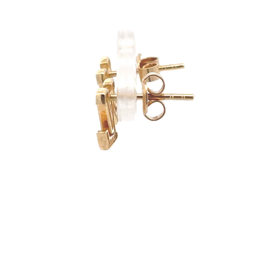 Pair of cubic zirconia gold stud earrings displayed on a jewelry stand