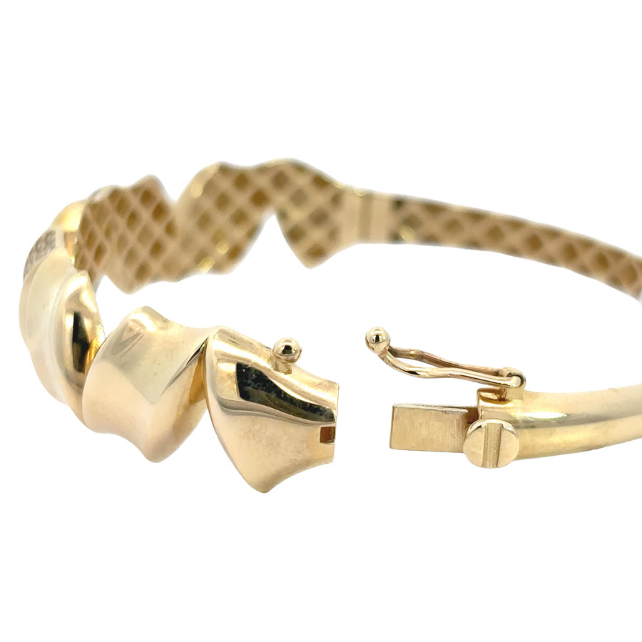 Woman wearing bold 14k gold solid bangle on wrist
