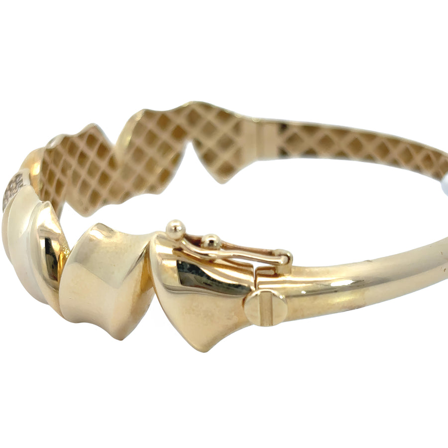 Stack of bracelets featuring 14k gold wide solid bangle