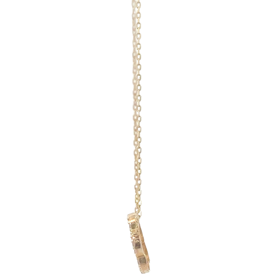 Close-up of 14k gold necklace with floral CZ pendant design