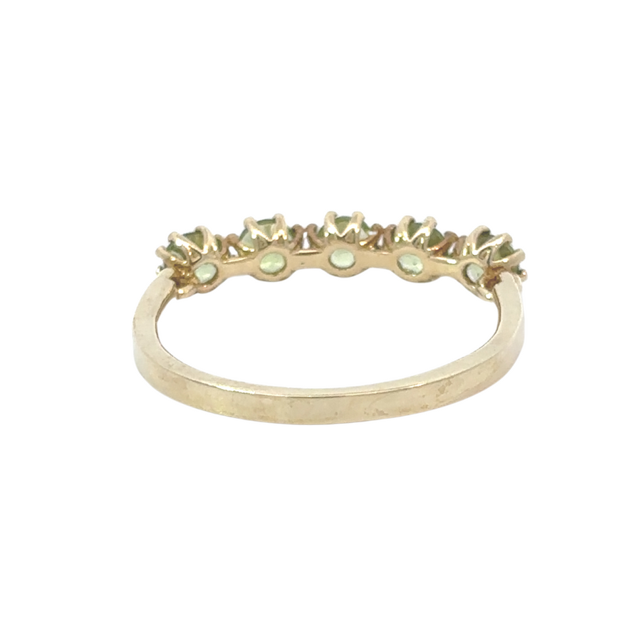 Top view showing symmetrical layout of five green stones on gold band