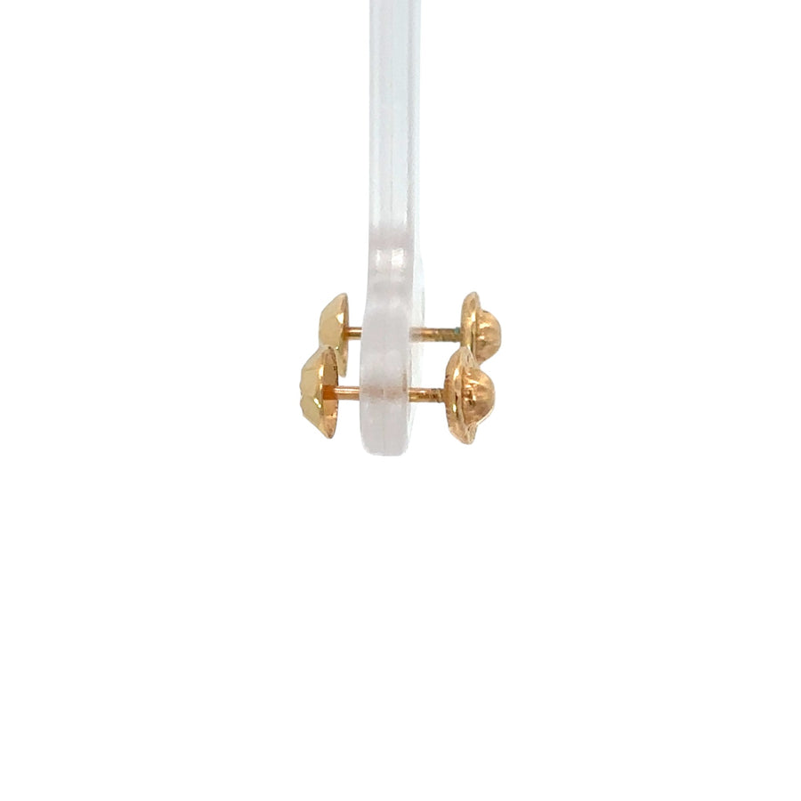 Baby wearing delicate 14k gold faceted stud earrings