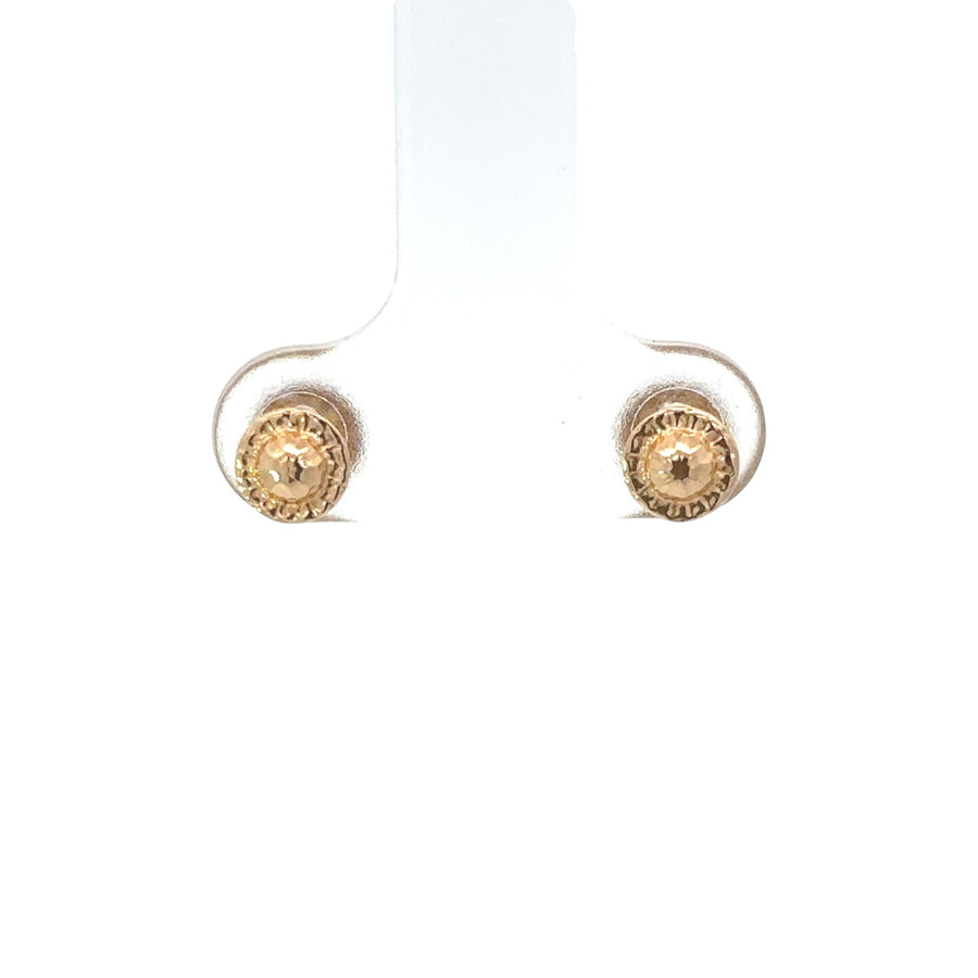 Pair of small 14k gold faceted stud earrings on white background