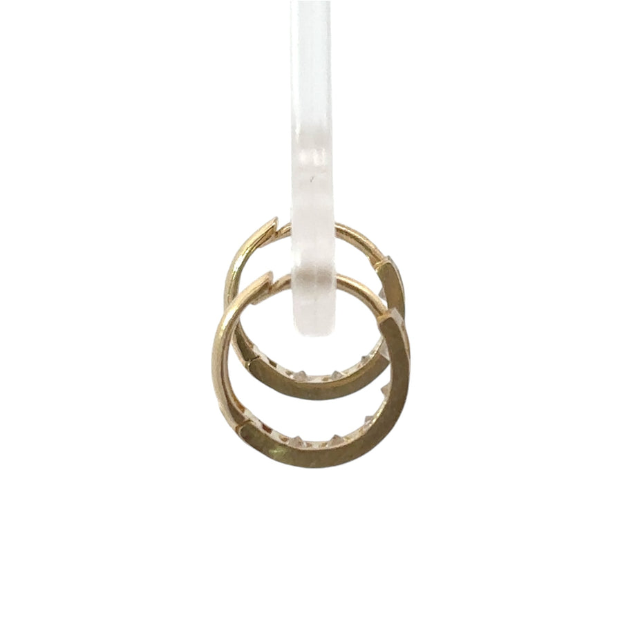 Close-up of petite gold huggie earrings with CZ line