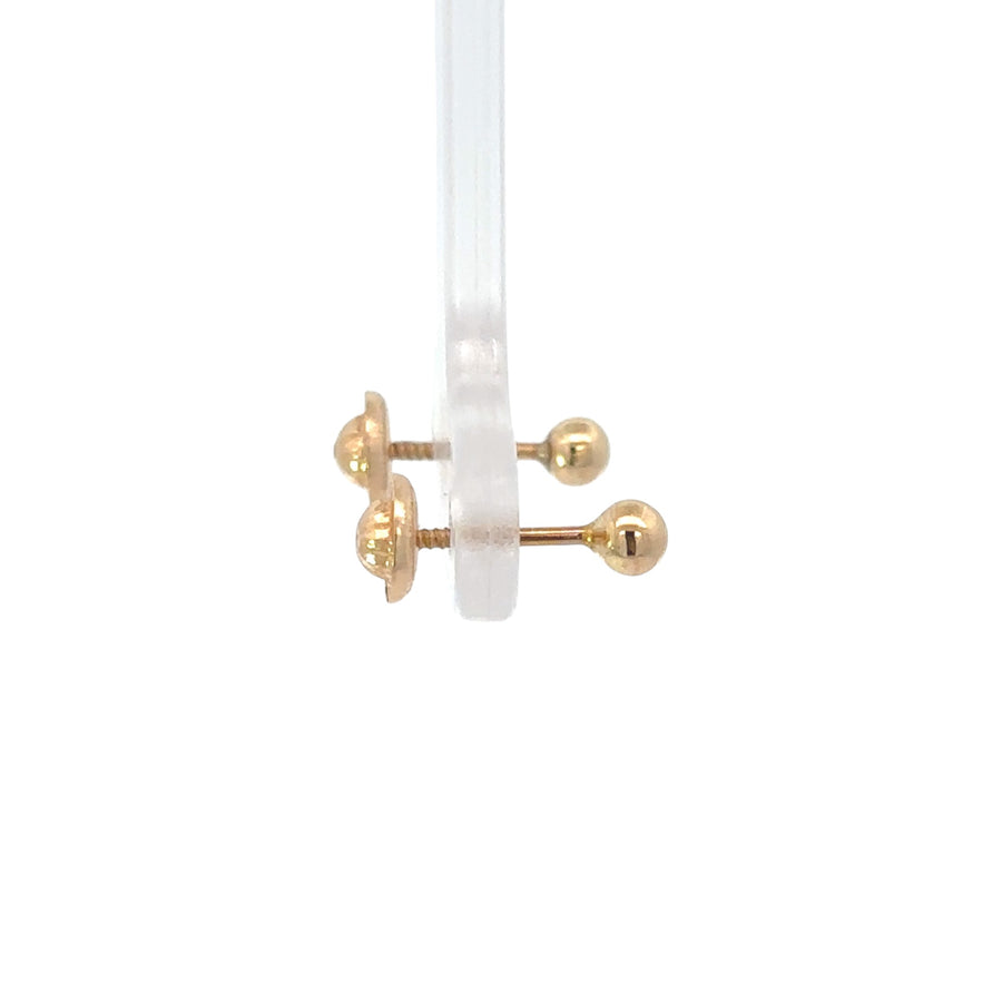 Baby wearing delicate 14k gold XS ball studs