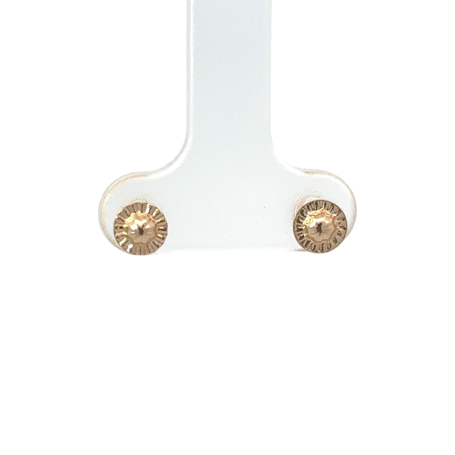 Woman’s ear adorned with delicate gold ball studs