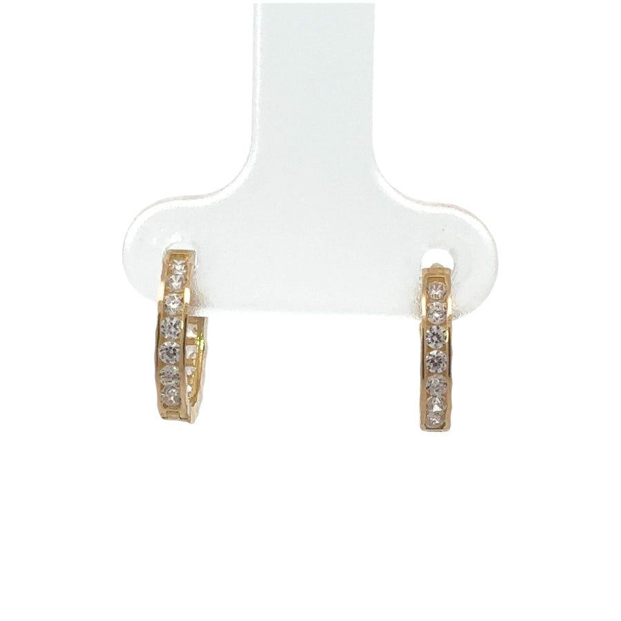 Close-up of delicate 14k gold huggie earrings with CZ stones