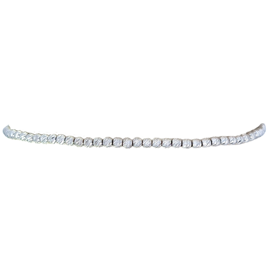 Close-up of minimalist white gold bracelet showing polished finish