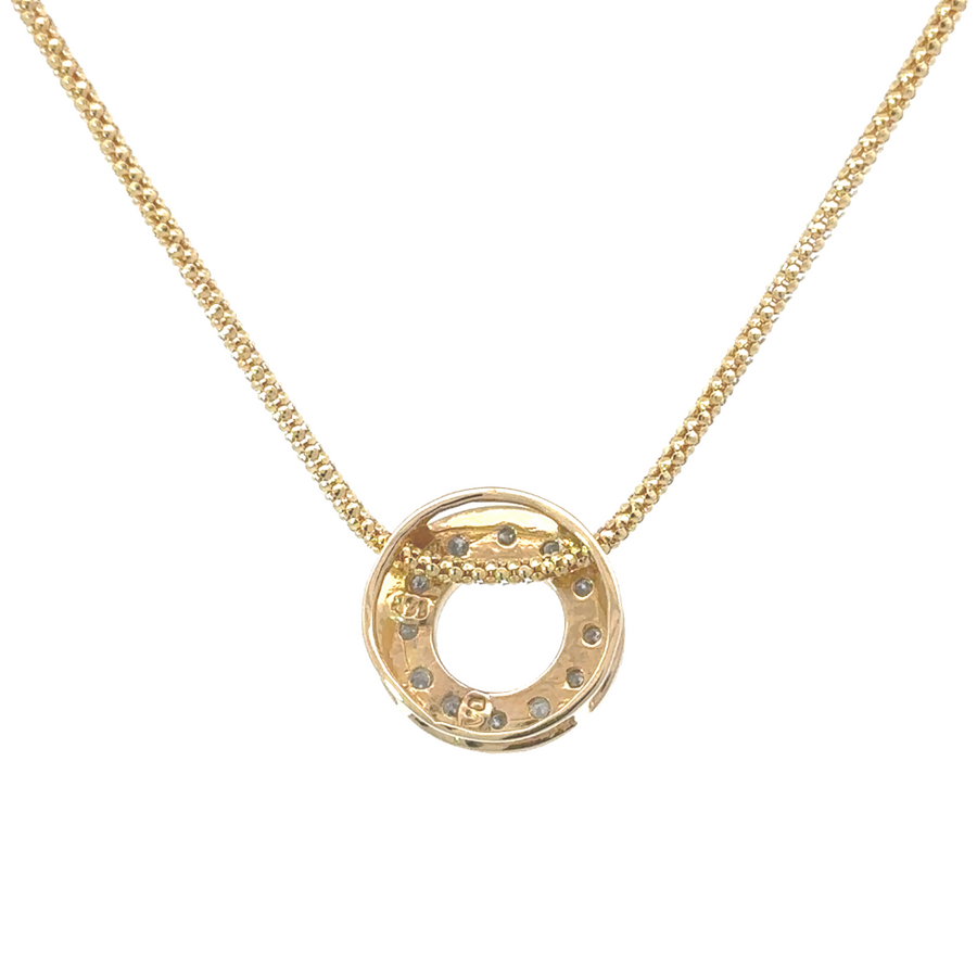 14k yellow gold circle pendant with pavé-set diamonds, worn on a chain