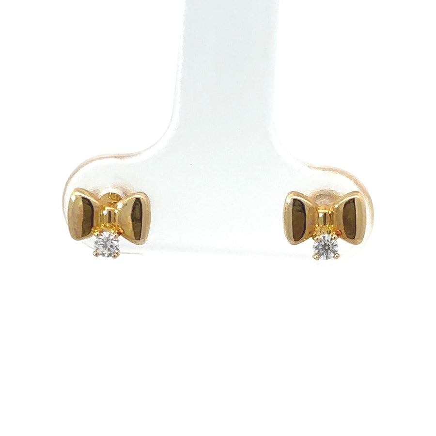 Pair of 18k gold baby earrings on soft white fabric