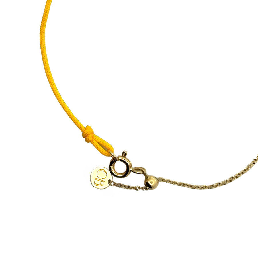 Bracelet laid flat showcasing yellow hilo and gold links
