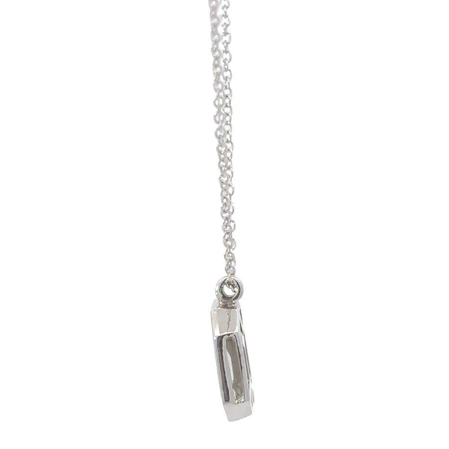 Woman wearing 18k gold necklace with sparkling diamond pendant, styled casually