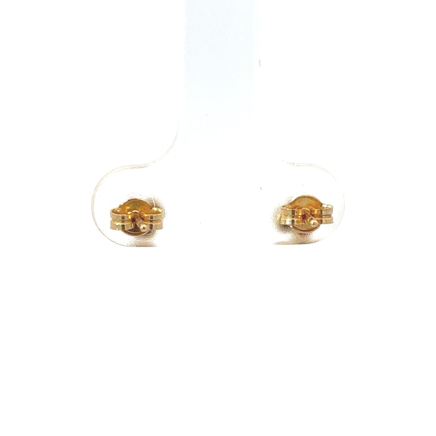 Close-up of 18k gold baby earrings with secure backing