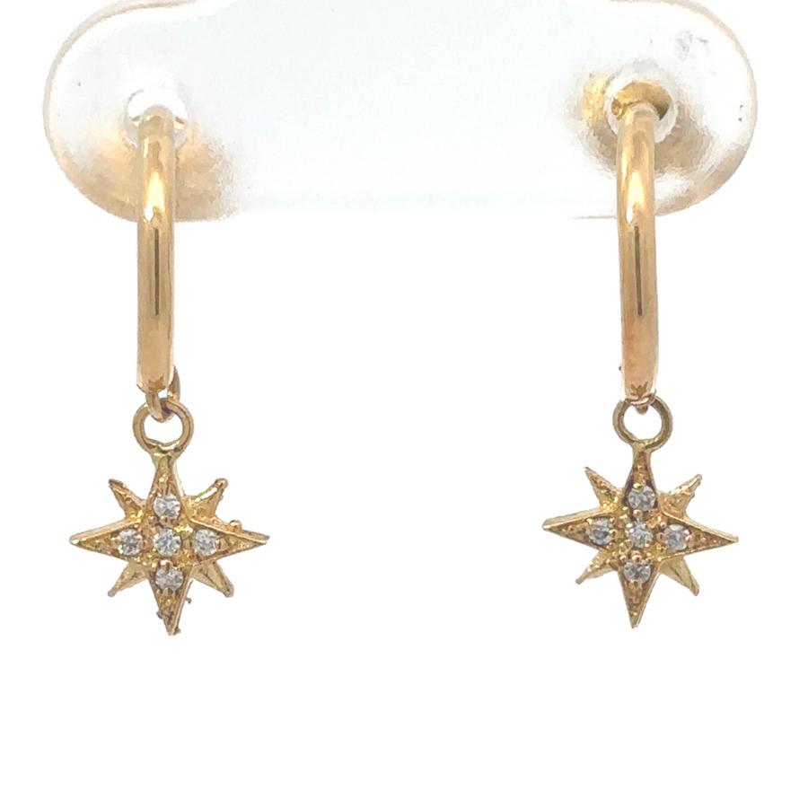 Close-up of 18k gold hoop earrings with star charm on neutral background
