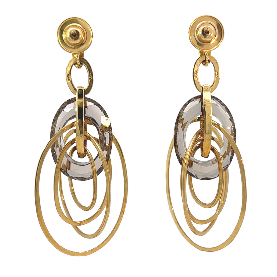 Woman wearing 18k gold hoops with smoky quartz accents