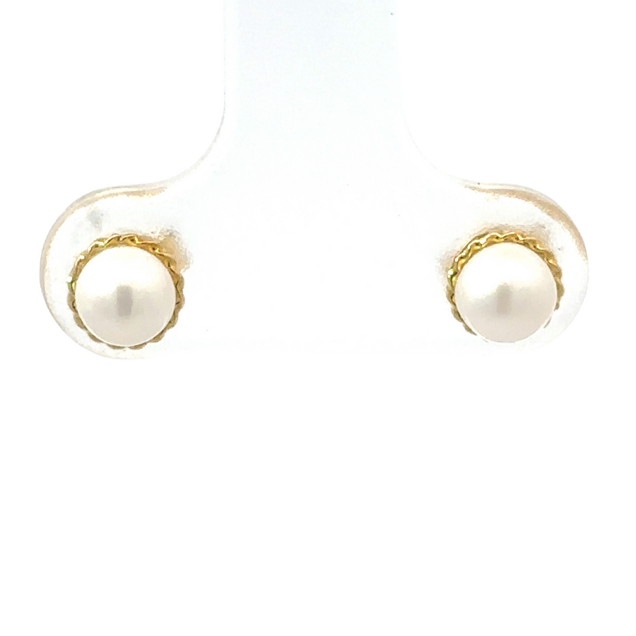 Close-up shot of 18k gold stud earrings with a minimalist design