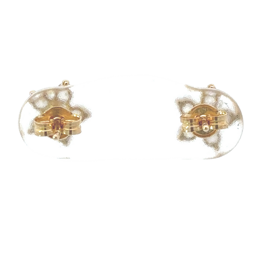 18k gold stud earrings resting on soft baby blanket background