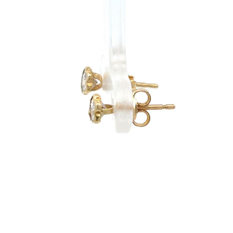 18k gold star-shaped stud earrings on a soft, textured background
