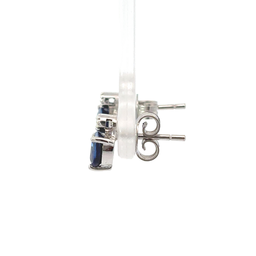 Side view of gold earring featuring round blue stone