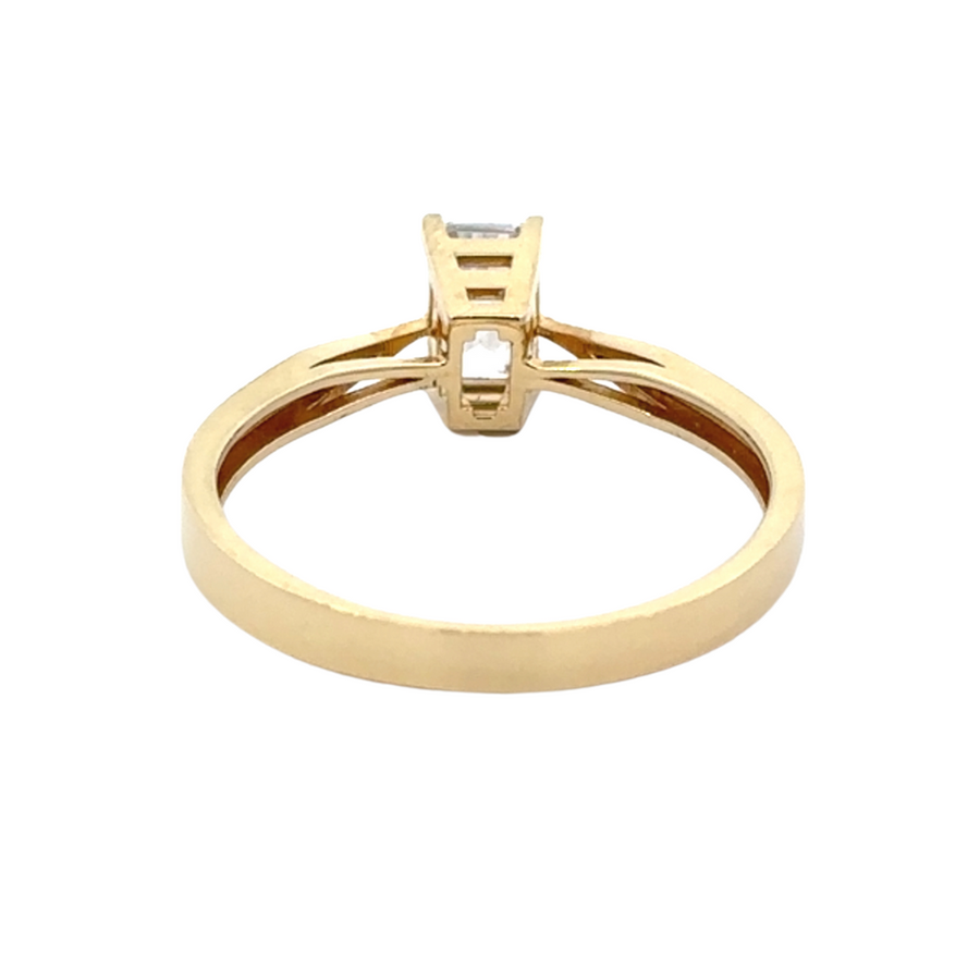 Elegant 14K gold solitaire ring with a brilliant rectangular CZ, worn on a model’s hand