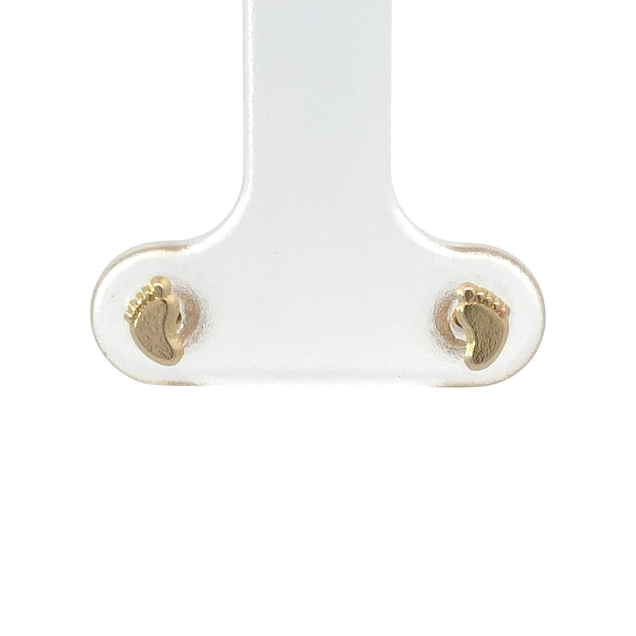 Close-up of tiny 14k gold earrings designed for infants