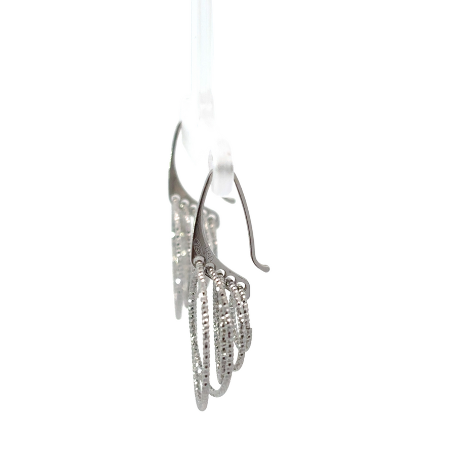 Close-up of silver earrings with diamond-cut detailing