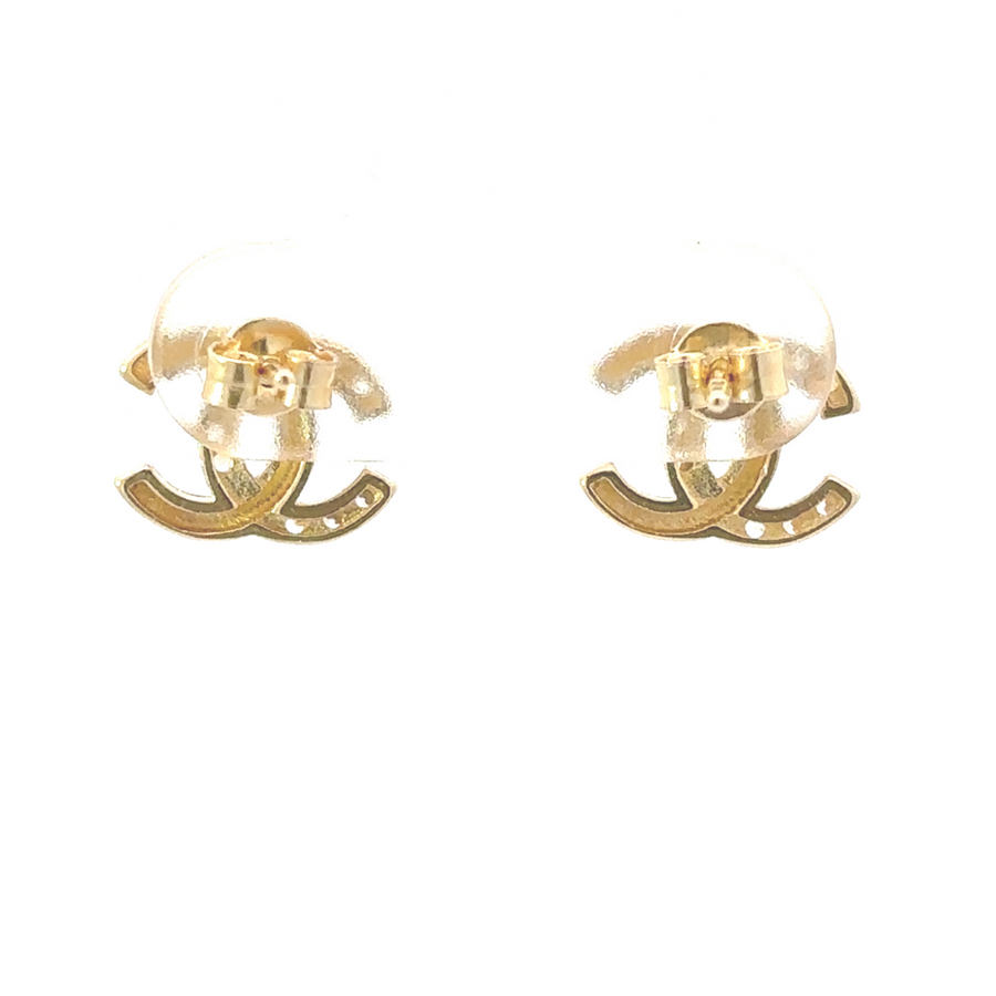 Gold earrings with CZ displayed on white velvet jewelry pad

