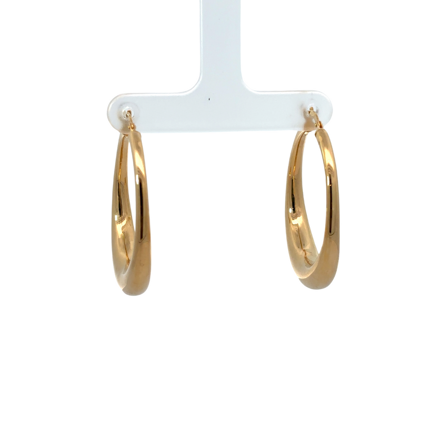 Close-up of polished 14k gold earrings on white background