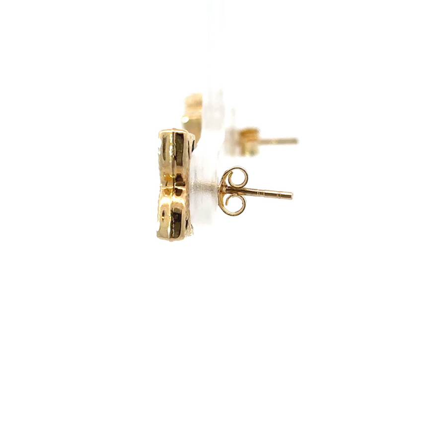 Pair of yellow gold and blue accent earrings laid flat on soft fabric