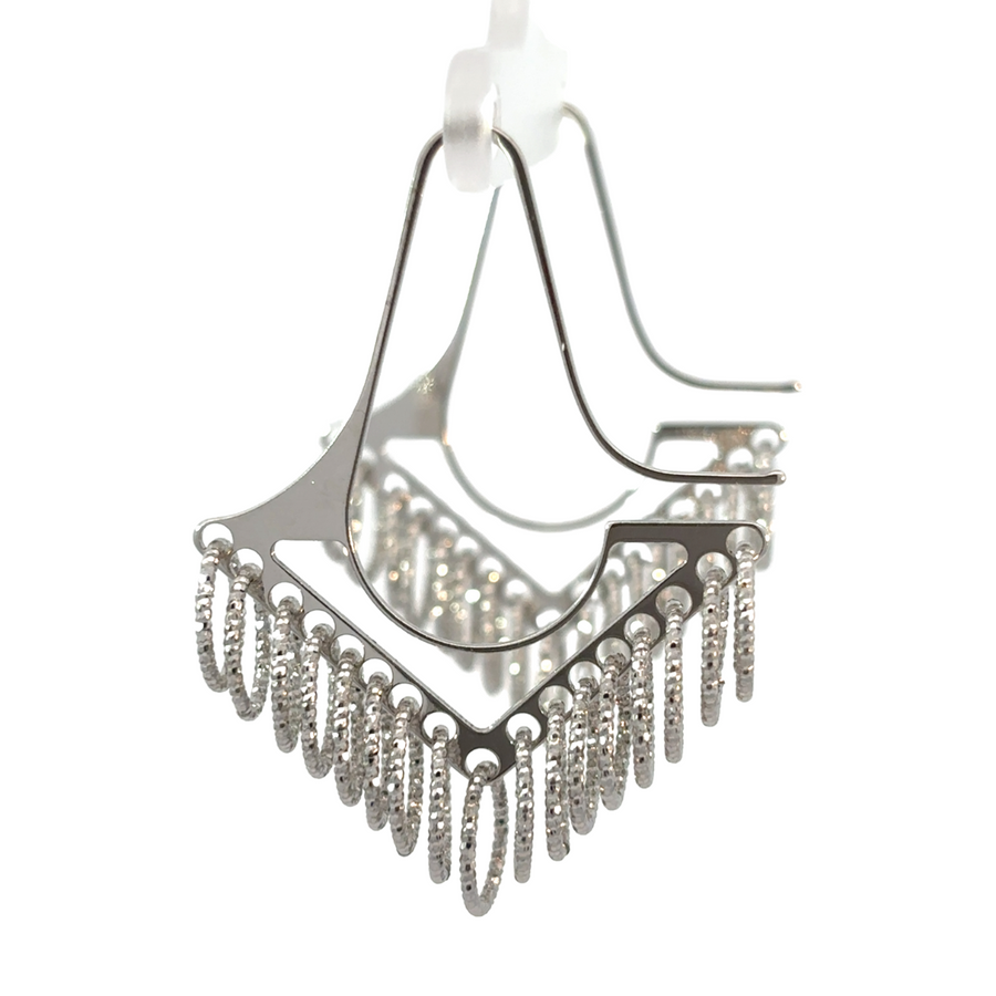 Close-up of silver earrings featuring arrow design and extra small circles